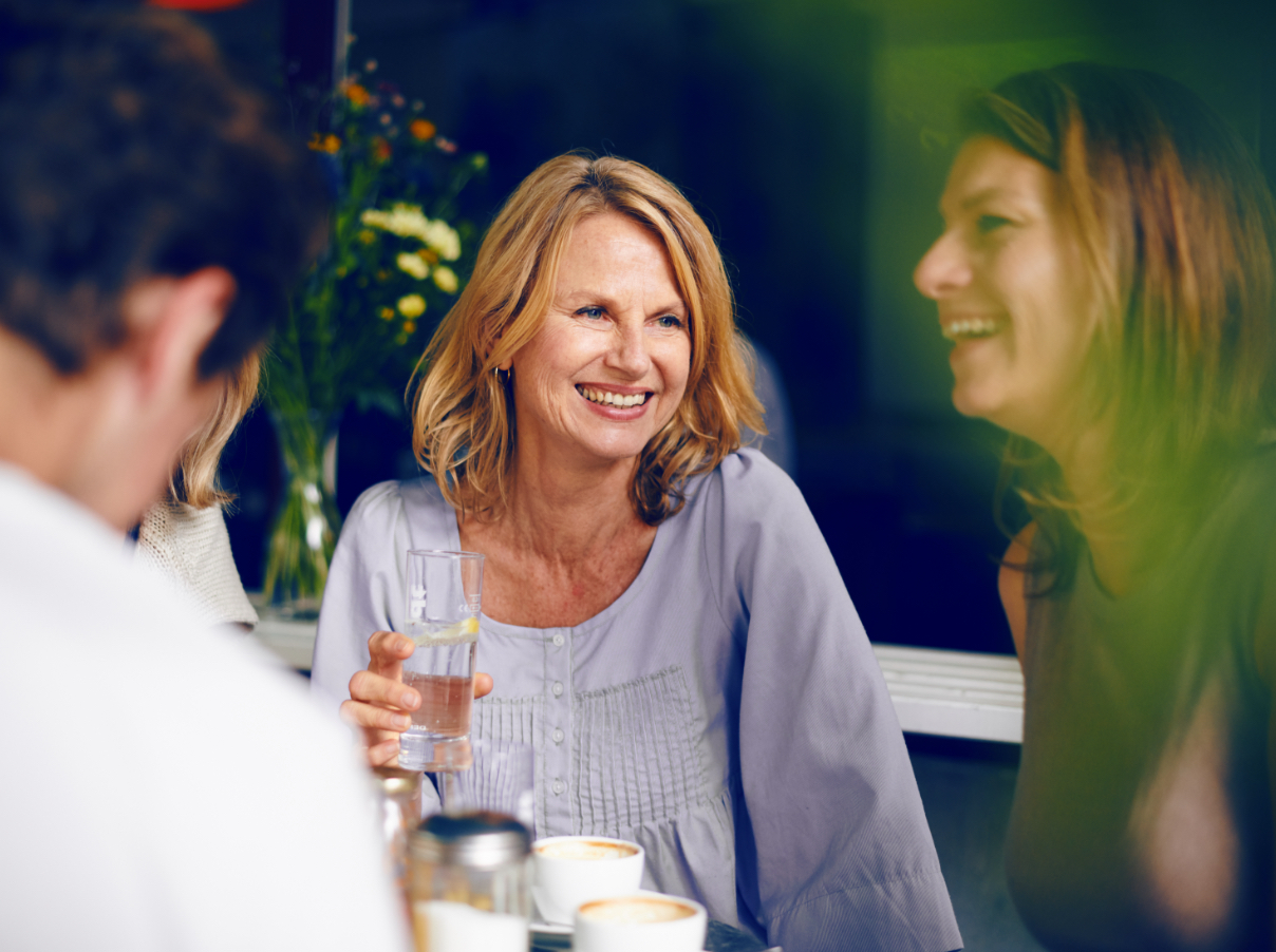 Une femme âgée discute dans un bar