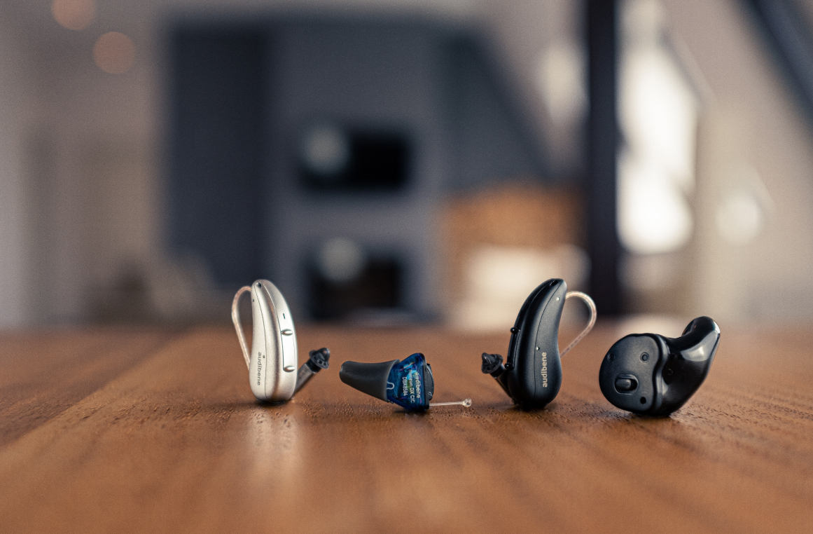 Différents modèles de mini appareils auditifs sur une table